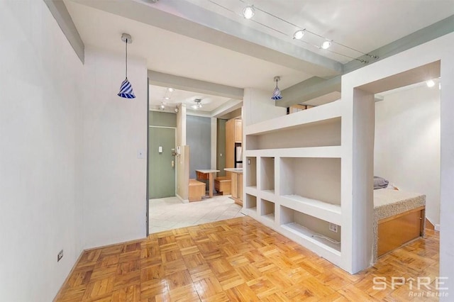 hallway featuring track lighting, light parquet flooring, and built in features