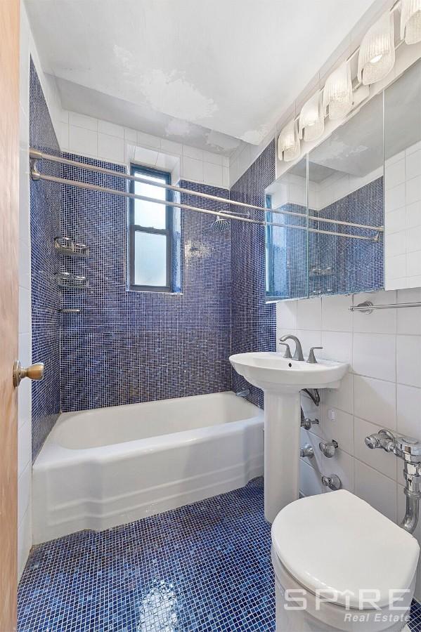 229 E 28th St Unit Lh, New York City, NY 10016 - full bath featuring washtub / shower combination, tile patterned flooring, and tile walls
