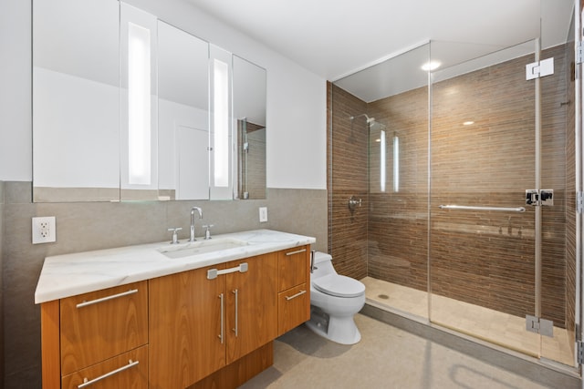 bathroom featuring vanity, toilet, an enclosed shower, and tile walls