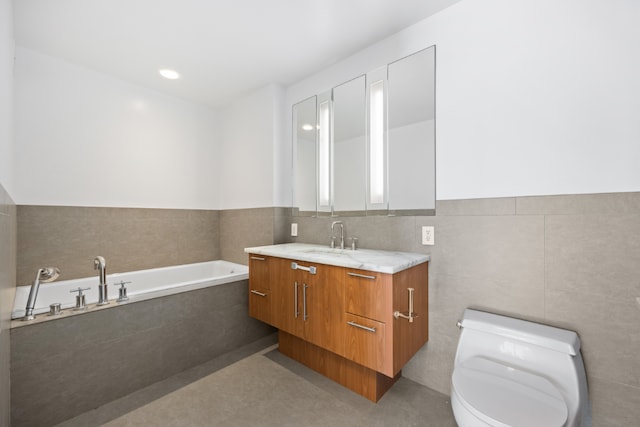 bathroom featuring vanity, a relaxing tiled tub, tile walls, and toilet