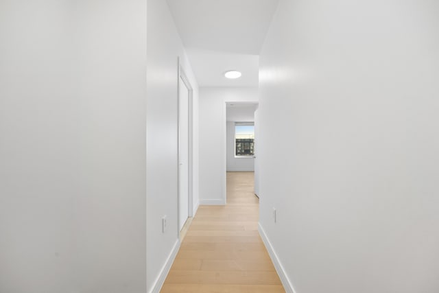 hall featuring baseboards and light wood-style flooring