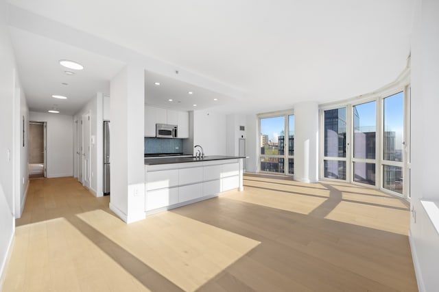 kitchen with dark countertops, white cabinets, modern cabinets, and stainless steel appliances