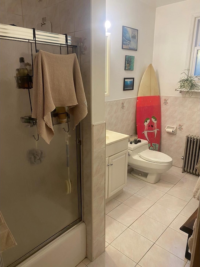 full bathroom featuring tile walls, toilet, radiator heating unit, vanity, and tile patterned floors