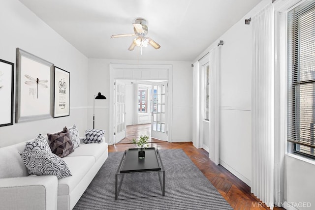 living room featuring dark parquet floors, french doors, and ceiling fan