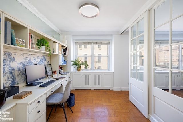 home office with crown molding, light parquet flooring, and built in desk