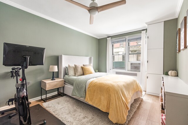 bedroom featuring crown molding, light hardwood / wood-style floors, and ceiling fan