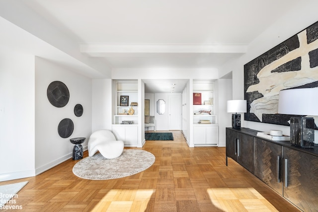 interior space with beam ceiling and baseboards