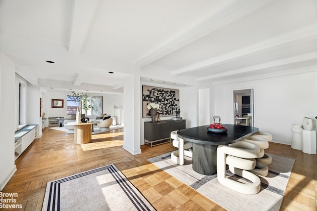 dining room featuring beamed ceiling and light parquet flooring