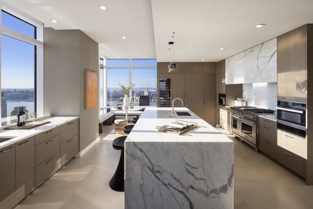 kitchen featuring sink, appliances with stainless steel finishes, backsplash, a spacious island, and decorative light fixtures