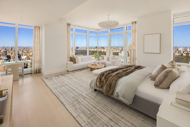 bedroom with multiple windows, light wood finished floors, and floor to ceiling windows