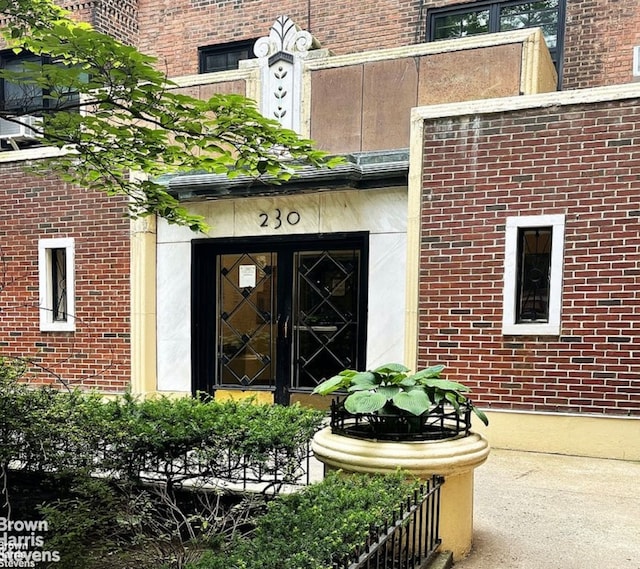 view of exterior entry featuring brick siding