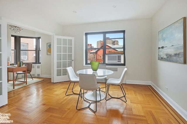 dining space with cooling unit, french doors, and light parquet floors