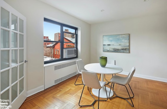 dining space featuring light parquet flooring and radiator heating unit