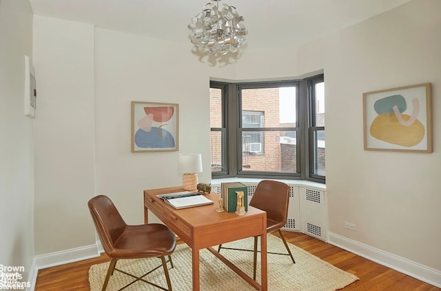 office space featuring radiator heating unit, wood-type flooring, and a chandelier