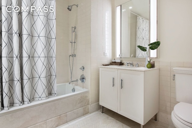 full bathroom featuring vanity, toilet, shower / bath combo with shower curtain, and tile walls