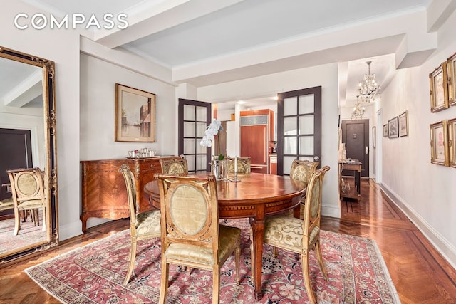 dining room with an inviting chandelier, baseboards, and crown molding