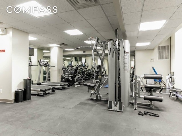 gym featuring baseboards, visible vents, and a drop ceiling