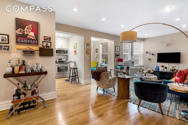 living area featuring light wood finished floors, baseboards, and recessed lighting