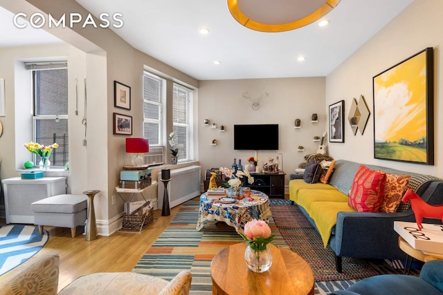 living room with baseboards, wood finished floors, and recessed lighting