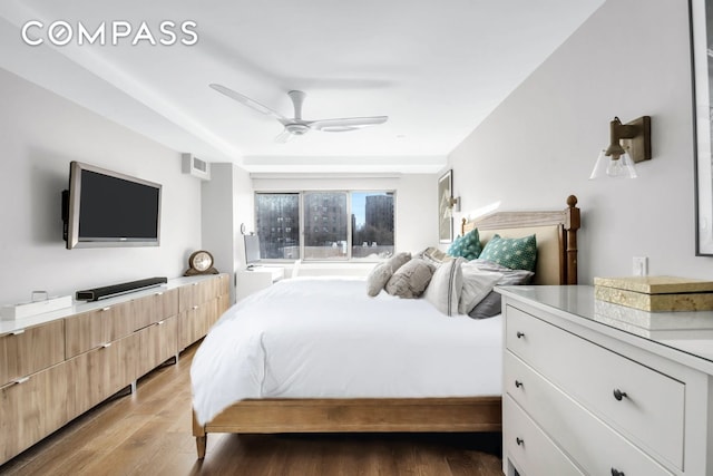 bedroom featuring visible vents, a ceiling fan, and light wood-style floors