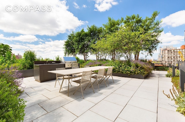 view of patio featuring grilling area, outdoor dining area, and exterior kitchen