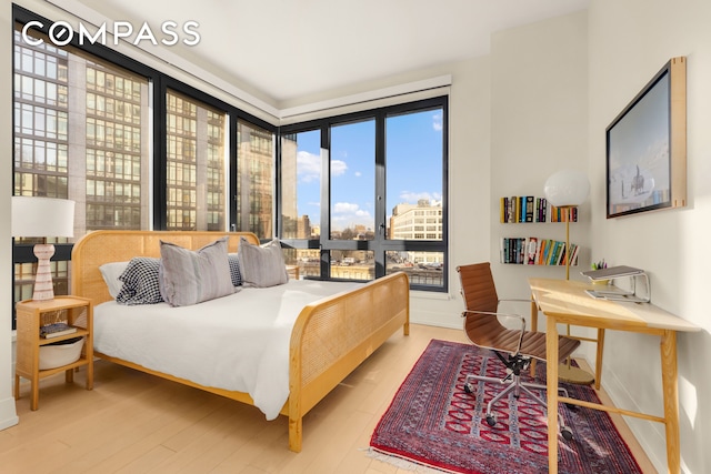 bedroom with a city view and wood finished floors