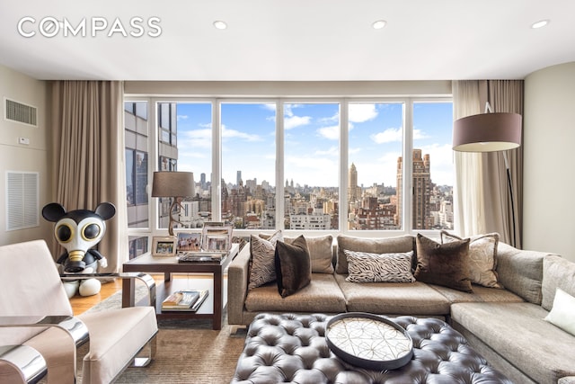 living room featuring a city view, visible vents, and a wealth of natural light