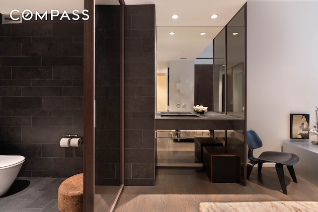 full bath featuring toilet, recessed lighting, tile walls, and a shower