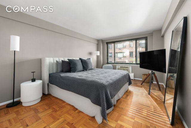 bedroom with an AC wall unit and light parquet floors