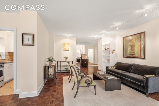 living area featuring track lighting and baseboards