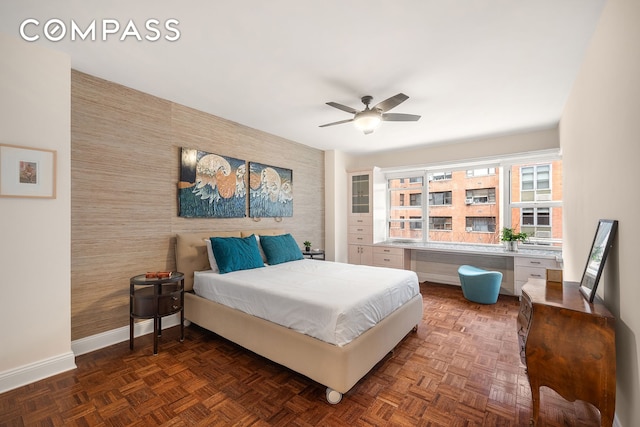 bedroom with baseboards, an accent wall, radiator heating unit, and wallpapered walls