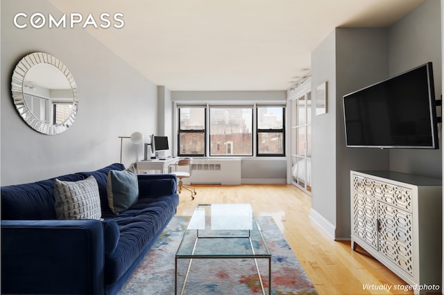 245 E 24th St Unit 9B, New York City, NY 10010 - living area with light wood-style floors, healthy amount of natural light, radiator heating unit, and an office area