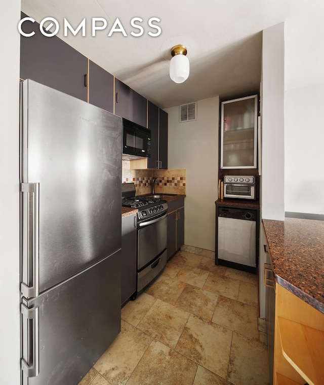 245 E 24th St Unit 9B, New York City, NY 10010 - kitchen featuring appliances with stainless steel finishes, tasteful backsplash, light stone finish flooring, and dark stone countertops