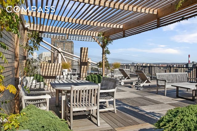 wooden terrace with outdoor dining space and a pergola