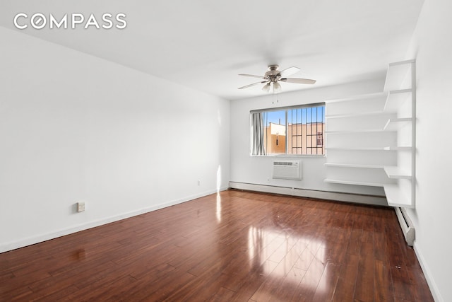 empty room featuring a wall mounted air conditioner, dark wood finished floors, baseboards, and ceiling fan