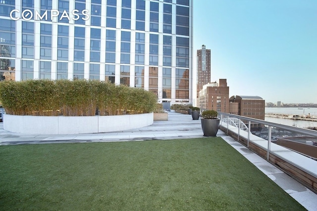 exterior space featuring a water view, a view of city, and a lawn