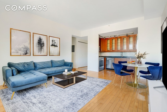 living area featuring light wood-style flooring and bar