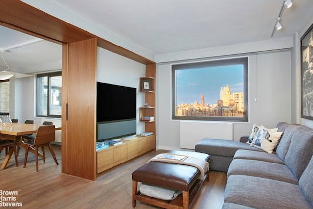 10 W 66th St Unit 22Abc, New York City, NY 10023 - living area featuring rail lighting, wood finished floors, and radiator heating unit