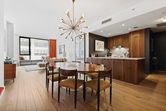 dining space with recessed lighting, visible vents, a notable chandelier, and light wood-style flooring