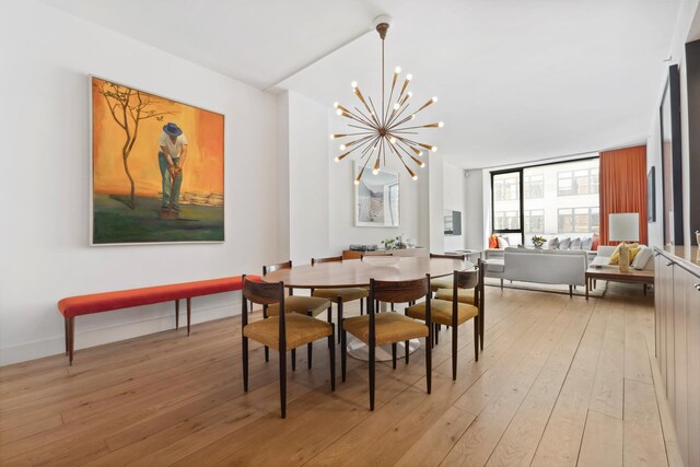 dining space with a notable chandelier and light hardwood / wood-style flooring