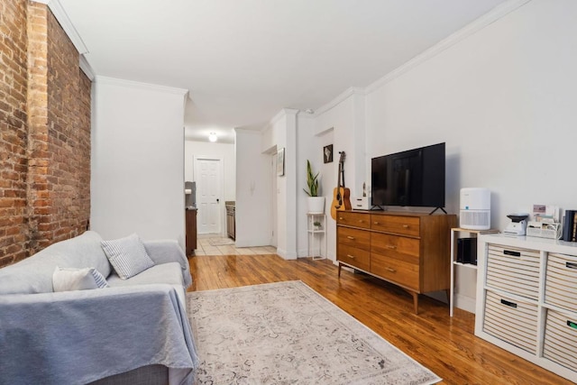 living room with crown molding, brick wall, and wood-type flooring