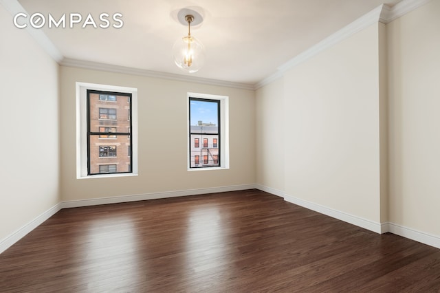 unfurnished room featuring dark wood finished floors, crown molding, and baseboards