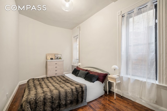 bedroom featuring baseboards and wood finished floors