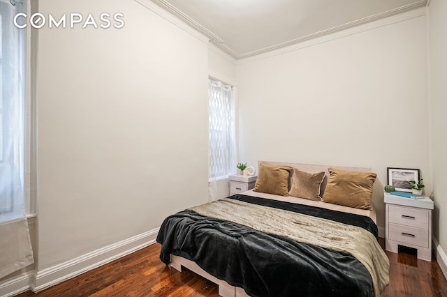 bedroom featuring baseboards, dark wood-type flooring, and ornamental molding