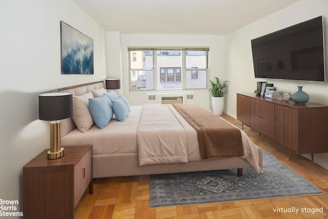 bedroom featuring a wall unit AC and light parquet flooring