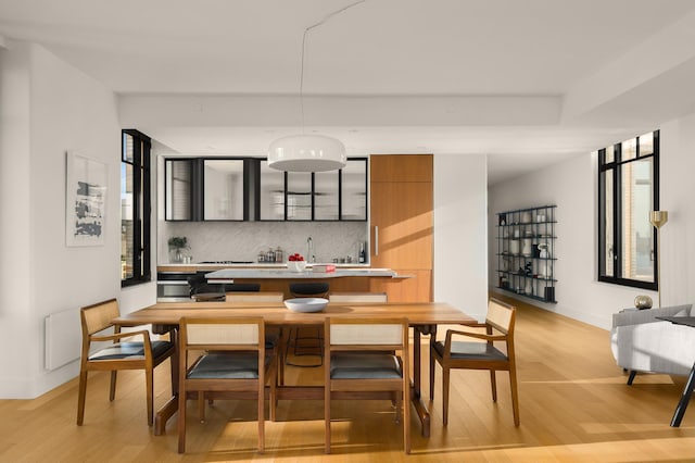 dining space with light wood finished floors and baseboards