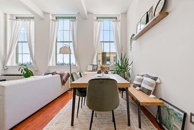 dining room featuring beam ceiling and wood finished floors