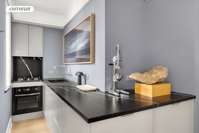 kitchen with sink, crown molding, black oven, gas cooktop, and decorative backsplash