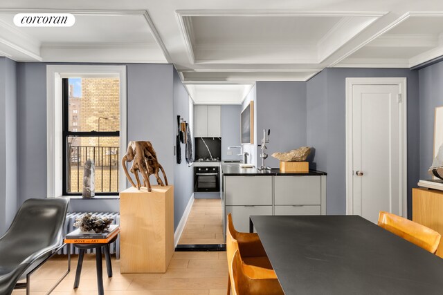 interior space featuring ornamental molding, sink, and light hardwood / wood-style flooring