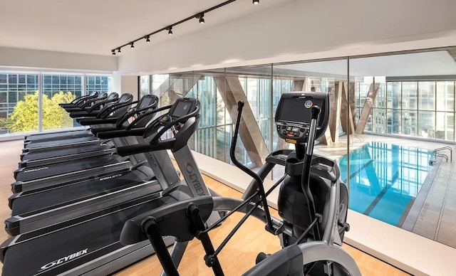 exercise room with track lighting and wood finished floors